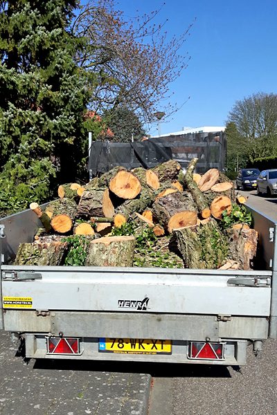 Aanhangwagen geladen met gezaagde boomstammen klaar voor afvoer