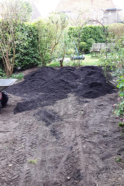 Verse tuingrond aangebracht op een leeggehaalde tuin tijdens een tuinrenovatie